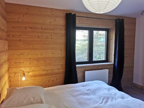 une chambre avec un grand lit et une fenêtre dans l'établissement Grand appartement 200m2 au pied des pistes, à La Giettaz