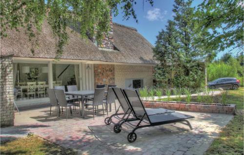 un patio con tavolo e sedie di fronte a una casa di Four-Bedroom Holiday Home With A Fireplace In Rømø a Toftum