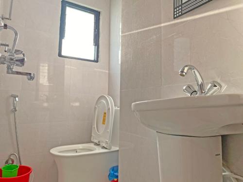 a bathroom with a sink and a toilet and a window at Hotel Airport Holiday in Kathmandu