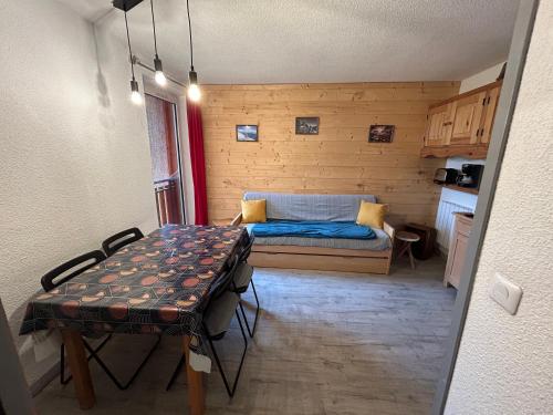 une petite pièce avec un lit et une table dans l'établissement appartement douillé, à Les Deux Alpes