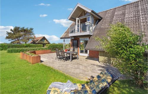 a house with a patio with a table and chairs at 4 Bedroom Nice Home In Assens in Assens