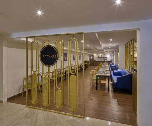 a restaurant with a dining table and gold bars at Grand Continent Brookefield - A Sarovar Portico Affiliate Hotel in Bengaluru