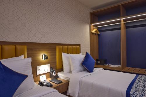 a hotel room with two beds and a window at Grand Continent Brookefield - A Sarovar Portico Affiliate Hotel in Bengaluru