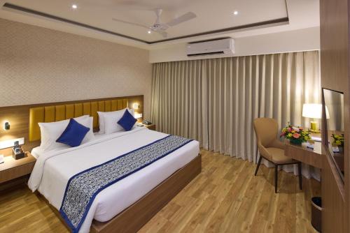 a hotel room with a bed and a desk at Grand Continent Brookefield - A Sarovar Portico Affiliate Hotel in Bengaluru