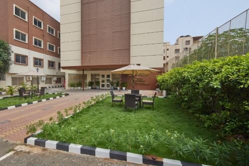 a courtyard with a table and chairs and an umbrella at Grand Continent Brookefield - A Sarovar Portico Affiliate Hotel in Bengaluru