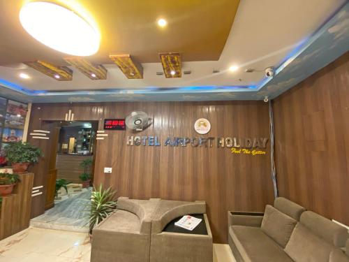 a waiting room with a couch and a sign on the wall at Hotel Airport Holiday in Kathmandu