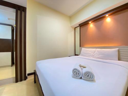 a bedroom with a bed with two towels on it at Spacious and Modern 2BR at Braga City Walk Apartment By Travelio in Bandung