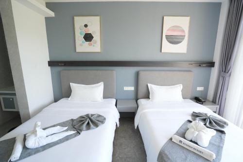 two beds in a room with towels on them at Bohol Panglao Begonia Resort in Panglao
