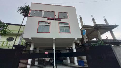 a white building with a sign on it at Shivam Guest House Near GNRC and Down Town Hospital in Dispur