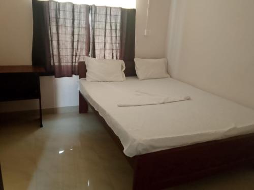 a small bed in a room with a window at Shivam Guest House Near GNRC and Down Town Hospital in Dispur