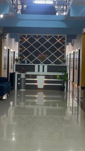 a lobby of a building with a wall of wine bottles at Nilastay emirates in Kazhakuttam