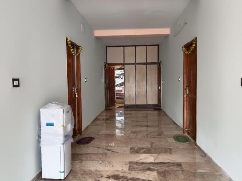 a hallway of a house with a refrigerator in it at Ponmurugan Residency in Kodaikānāl