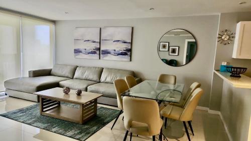 ein Wohnzimmer mit einer Couch und einem Glastisch in der Unterkunft Beachfront Resort 2BR Condo 3 Pools, Heated Pool, Kids Pool & Jacuzzi in South Padre Island