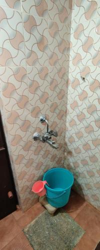 a bathroom with a blue bucket next to a sink at Stanrose Farm Stay in Kundapur