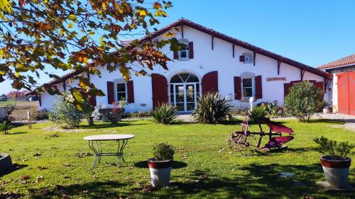 a white house with a table in the yard at La Coquille in Pouillon