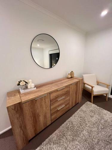a mirror on top of a wooden dresser in a room at 3 Bedroom House in Cooma in Cooma