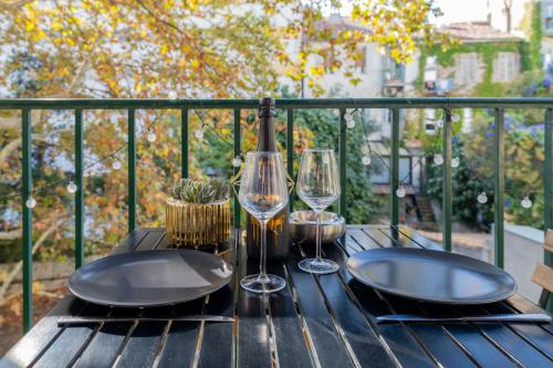 a table with two plates and wine glasses at Le carré d’or mermoz in Marseille