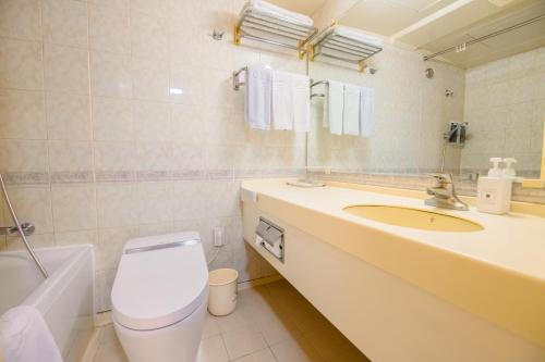a bathroom with a sink and a toilet and a mirror at Hotel International Changwon in Changwon