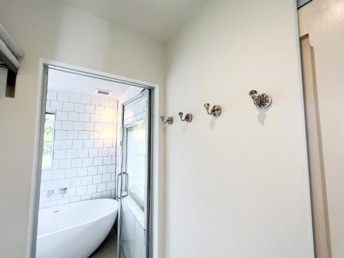 a white bathroom with a tub and a shower at HOLLY CAMP CASA in Akagina