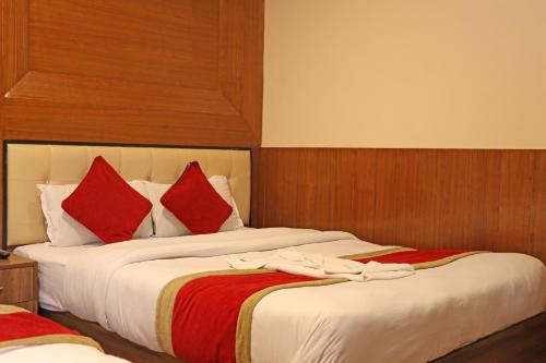 two beds in a hotel room with red pillows at Hotel Airport Holiday in Kathmandu