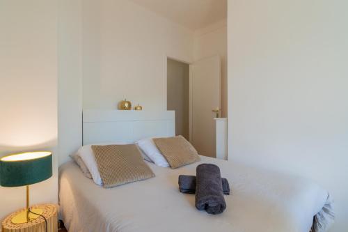 a bedroom with a white bed with two towels on it at Le carré d’or mermoz in Marseille