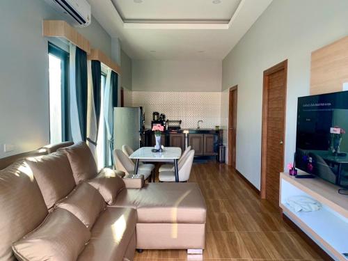 The M Millions Pool Villa, Aonang Krabi -Free Shuttle to Aonang Beach في شاطيء آونانغ: غرفة معيشة بها أريكة وطاولة