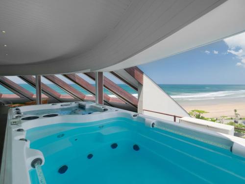 an indoor swimming pool with a view of the beach at Double - Six, Luxury Hotel - Seminyak in Seminyak