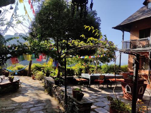 a garden with a table and chairs and a tree at Depche Village Resort in Bandīpur