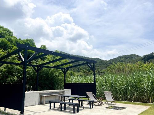 a picnic table and chairs sitting under a pergola at HOLLY CAMP CASA in Akagina