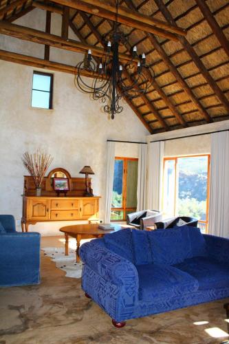a living room with a blue couch and a table at Bosch Luys Kloof Nature Reserve in Ladismith