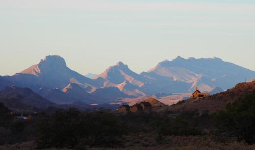 a view of a mountain range with houses in the foreground at Bosch Luys Kloof Nature Reserve in Ladismith