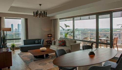 a living room with a table and chairs at Somerset Maslak Istanbul in Istanbul