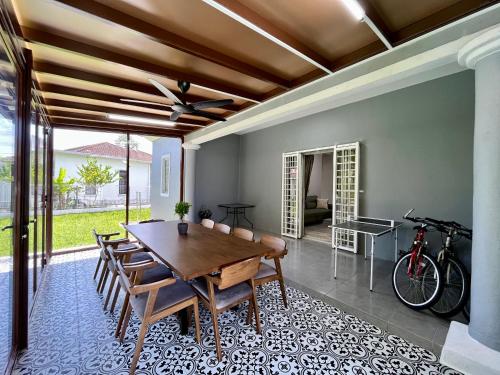 a dining room with a wooden table and chairs at The P Lakehouse in Tanjong Sepat