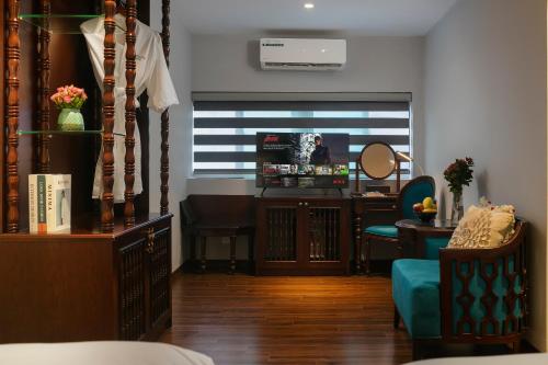 a room with a living room with a desk and a mirror at Serene Central Hotel in Hanoi