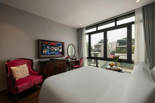 a bedroom with a bed and a window and a tv at Serene Central Hotel in Hanoi