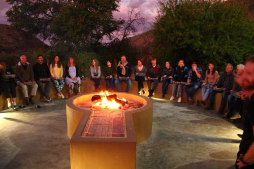 a group of people sitting around a fire pit at Bosch Luys Kloof Nature Reserve in Ladismith