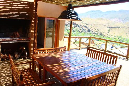 a wooden table and chairs in a room with a fireplace at Bosch Luys Kloof Nature Reserve in Ladismith