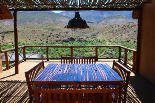 a blue table and chairs on a porch with a view at Bosch Luys Kloof Nature Reserve in Ladismith