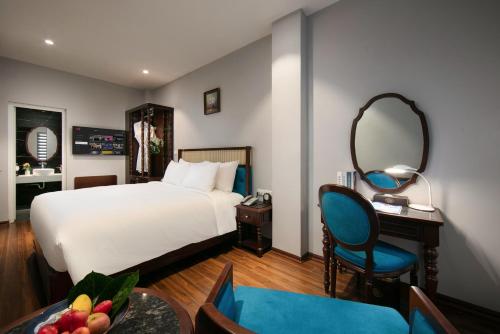 a bedroom with a bed and a desk and a mirror at Serene Central Hotel in Hanoi