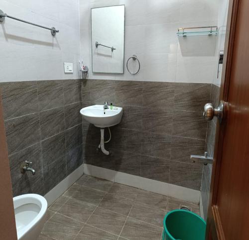 a bathroom with a sink and a toilet at Azhagappa Residency in Puducherry