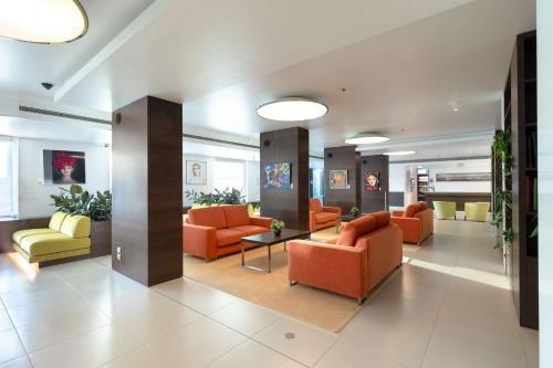 a lobby with orange and yellow chairs and tables at Hilton Garden Inn Venice Mestre in Mestre