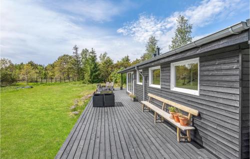 a wooden deck with two benches on a house at Amazing Home In Ålbæk With Kitchen in Ålbæk