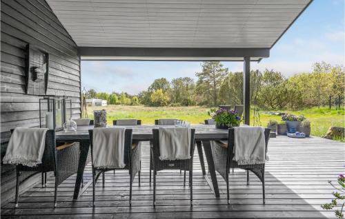 a patio with a table and chairs on a deck at Amazing Home In Ålbæk With Kitchen in Ålbæk
