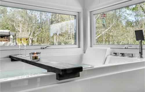a bathtub with a glass counter in front of a window at Amazing Home In Ålbæk With Kitchen in Ålbæk