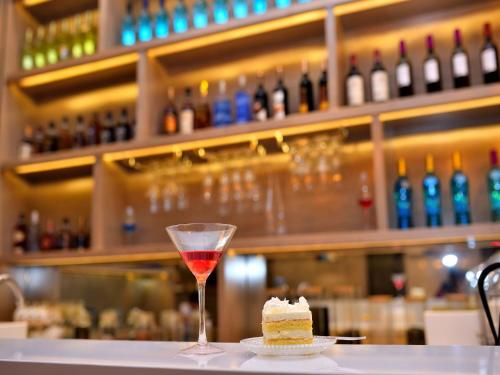 a glass of wine and a piece of cake on a table at Echarm Hotel Kunming Baita Road Huidu International Store in Kunming