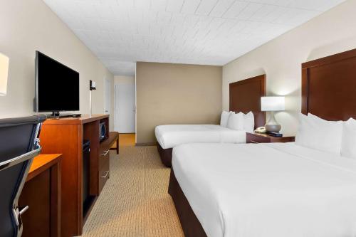 a hotel room with two beds and a flat screen tv at Comfort Inn Somerset in Somerset