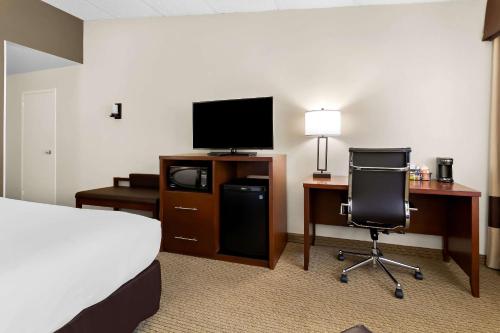 a hotel room with a bed and a desk with a television at Comfort Inn Somerset in Somerset