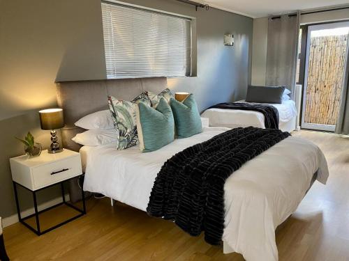 a bedroom with two beds with pillows and a window at Rose’s Place in Durbanville