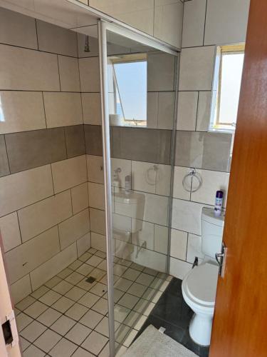 a bathroom with a toilet and a glass shower at Eagles View Kungwini in Erasmus