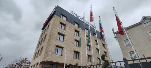 a building with two flags on top of it at Cozy Hotel in Bishkek